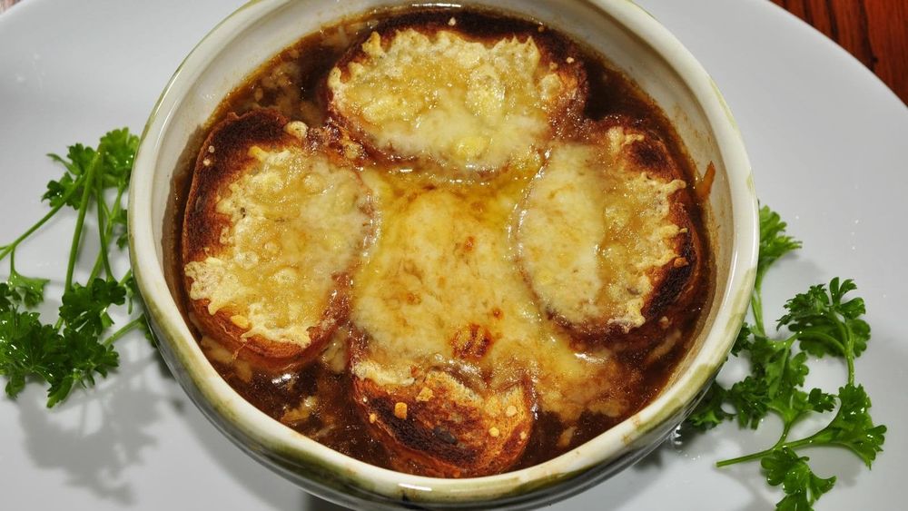 French onion soup gratinée with melted cheese toasts in a crock