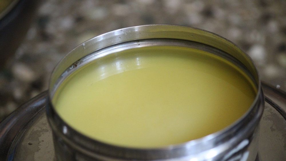 Homemade golden ghee in a steel container — photo for the seed-oil-free guide: Ghee vs Olive Oil