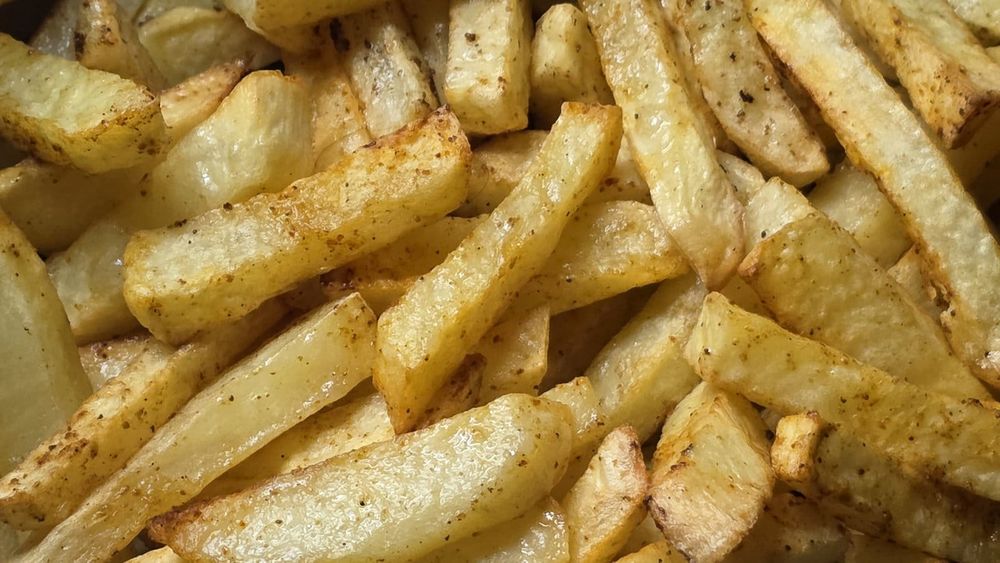 Close-up of golden, lightly seasoned chips cooked in an air fryer