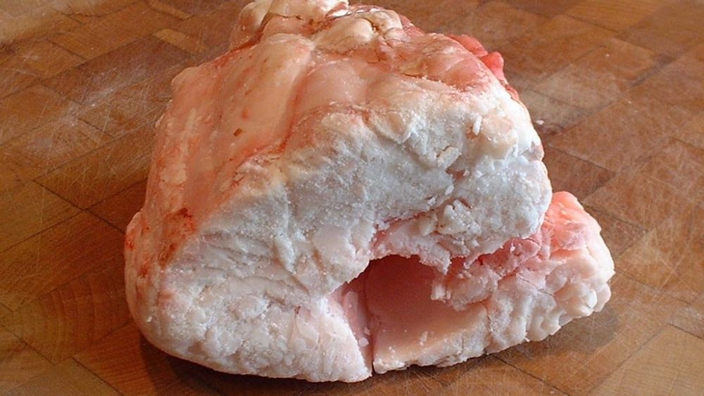 A lump of raw white suet on a wooden board — photo for the seed-oil-free guide: Tallow vs Suet