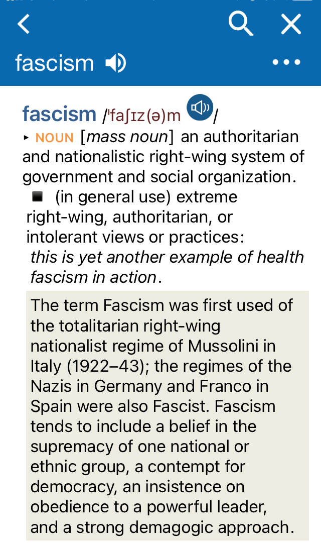 Screenshot from the Oxford English Dictionary (OED) app for iOS, in particular its definition of the word fascism:   fascism /faʃiz(ə)m ▸ NOUN [mass noun] an authoritarian and nationalistic right-wing system of government and social organization.  ◾ (in general use) extreme right-wing, authoritarian, or intolerant views or practices: "this is yet another example of health fascism in action." The term Fascism was first used of the totalitarian right-wing nationalist regime of Mussolini in Italy (1922-43); the regimes of the Nazis in Germany and Franco in Spain were also Fascist. Fascism tends to include a belief in the supremacy of one national or ethnic group, a contempt for democracy, an insistence on obedience to a powerful leader, and a strong demagogic approach.