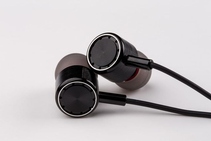 Close-up photograph of black wired in-ear earphones against a white background, by snsforyou. Image licenced through Pixabay. 
