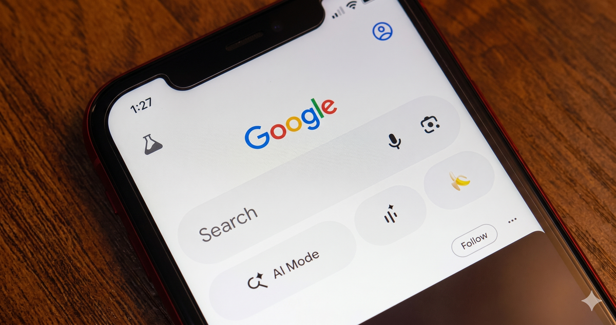 Close-up of a smartphone screen showing the Google search interface with the logo, search bar, icons, and current time set to 1:27.