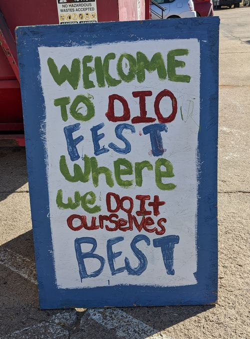 a hand painted wooden sign reading 'welcome to DIO Fest where we Do It Ourselves Best