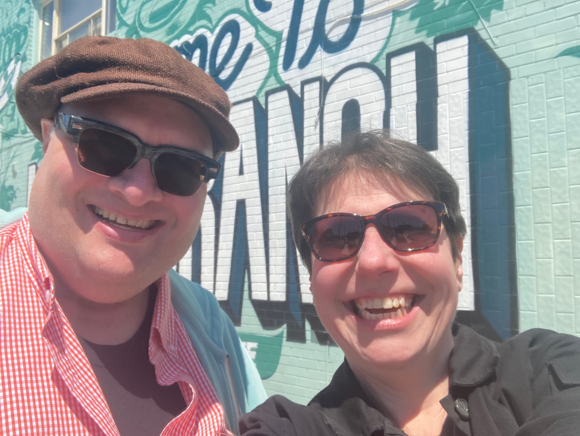 Jonathan and me, both wearing shades and grinning from ear to ear, in front of the green 'Welcome to Long Branch' sign at Lake Shore and Thirtieth.