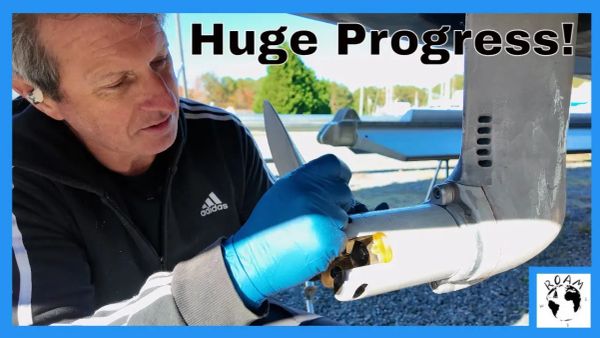 Engines being lifted into place on a cruising catamaran using a DIY bridge crane during a major refit milestone.