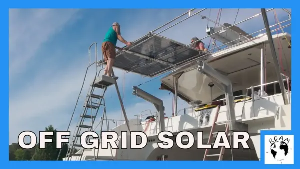 High in the air, two of the four 570 watt solar panels on the arch and shawn on a sketchy ladder.