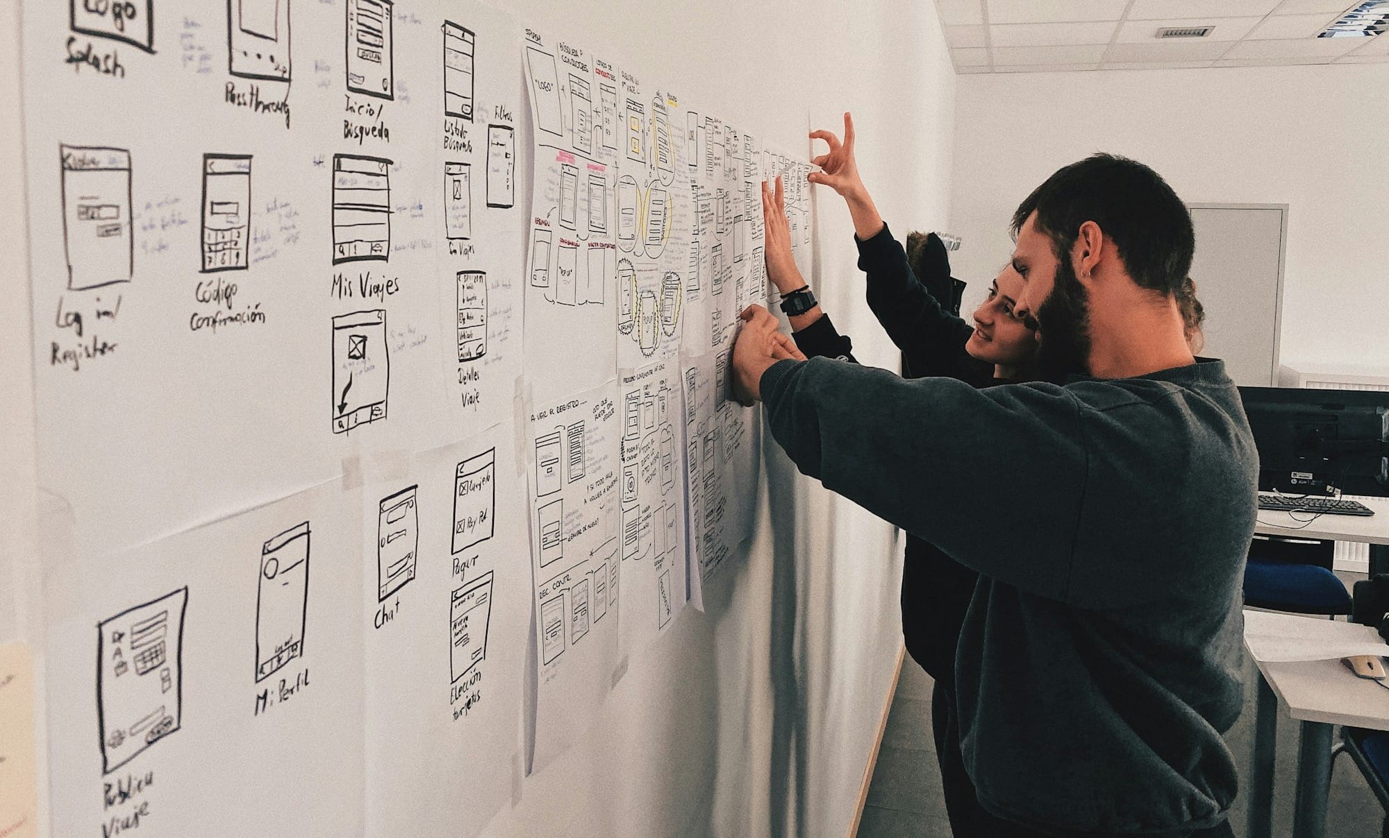 man in gray sweater standing beside wall