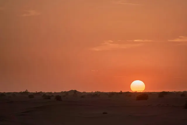 Walking towards the horizon line to touch a desert sunrise.