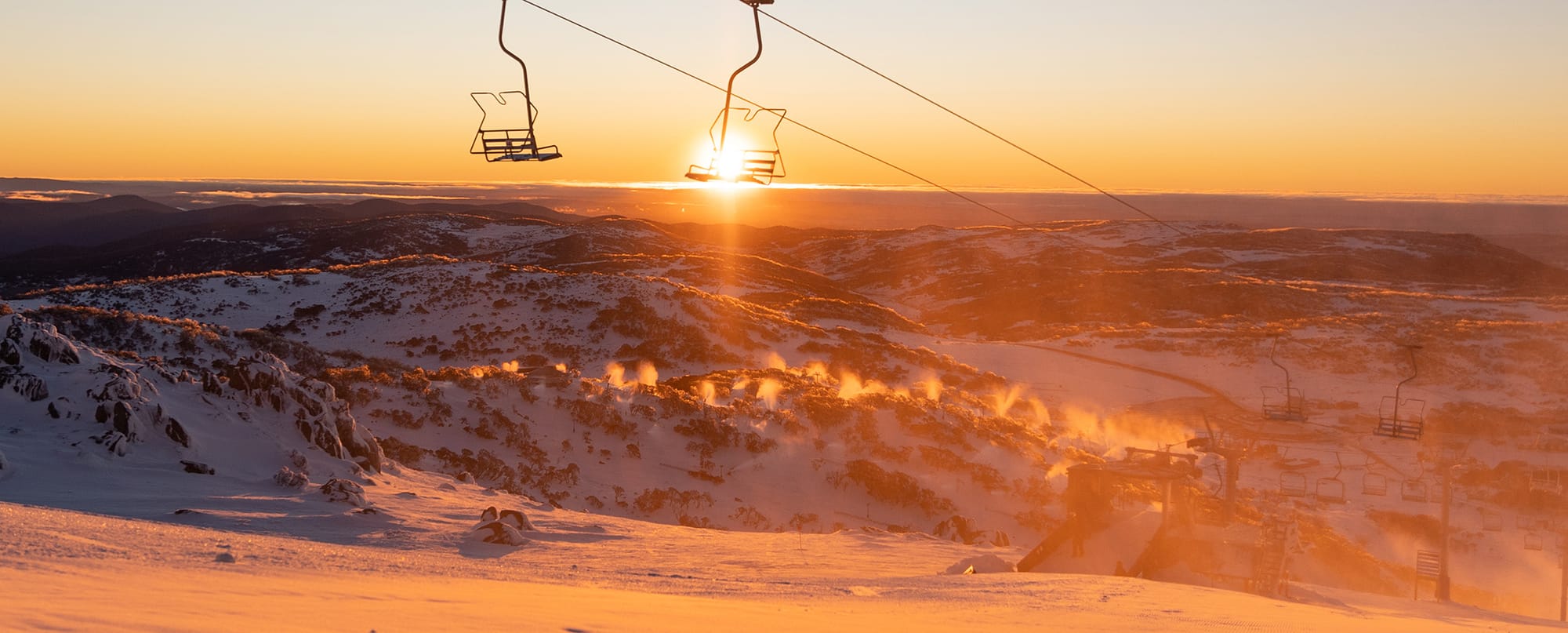 The glow as the sunrise hits the snowmaking plumes.