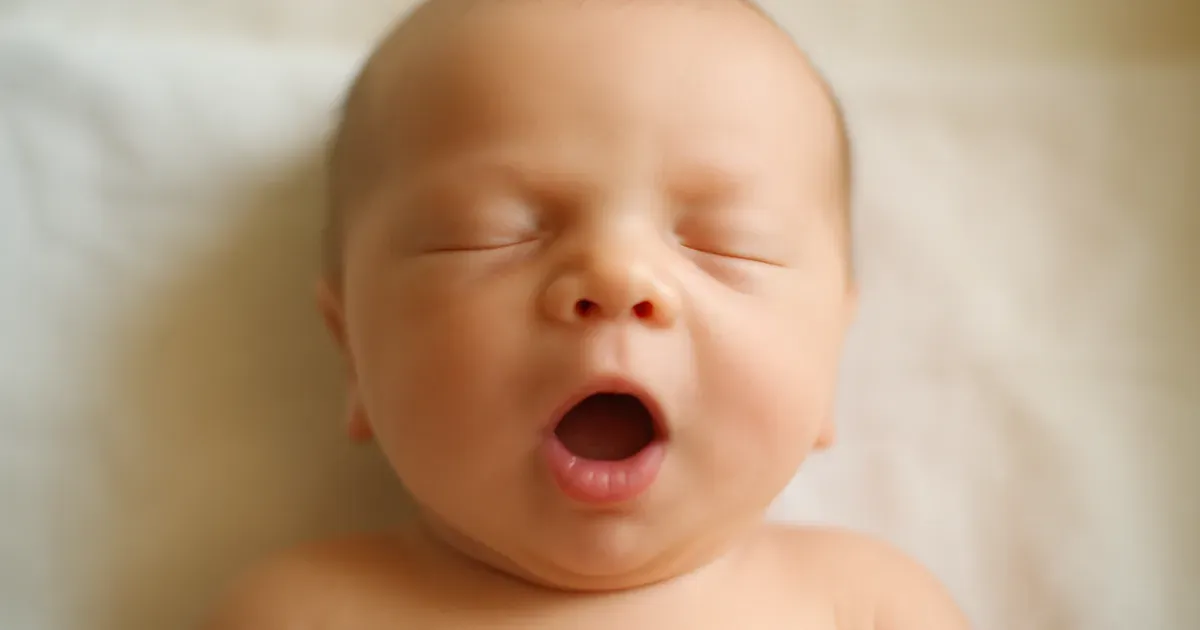 Newborn baby's open mouth representing the start of oral microbiome development at birth