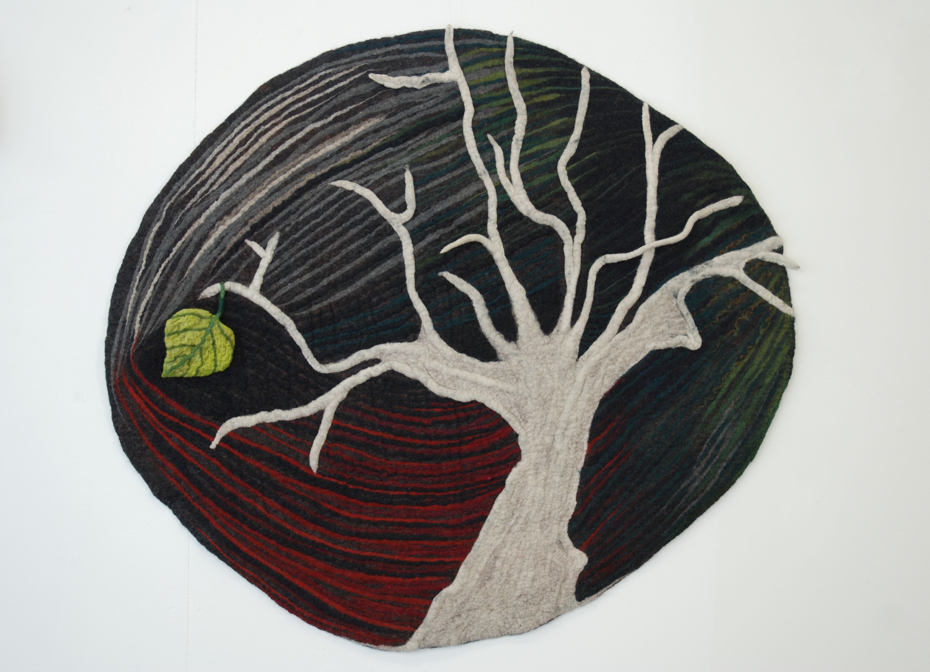 Felted picture of a tree with a single leaf. "The last"