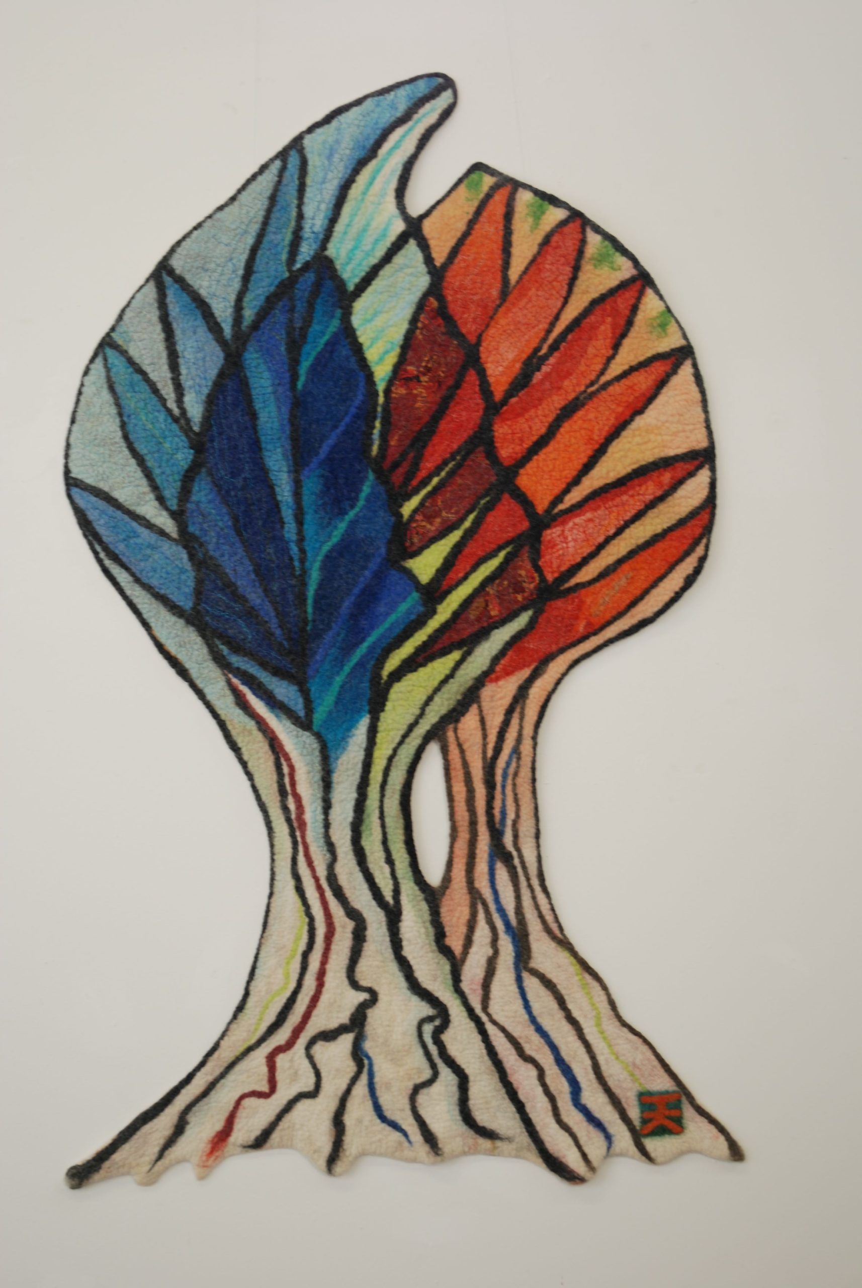 Felted picture of two trees in red and blue grown together. The name of the work is "Toghether".