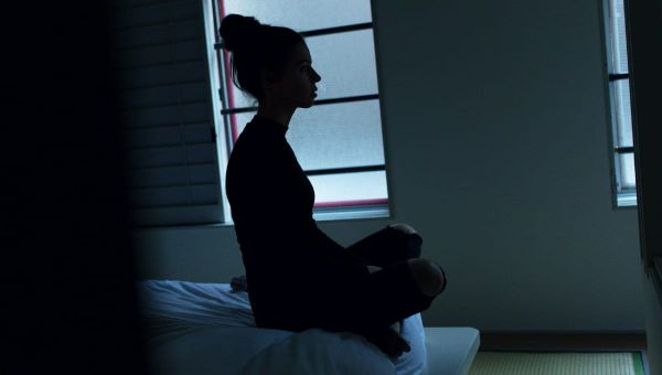 Persona pratica la respirazione consapevole seduta vicino a una finestra