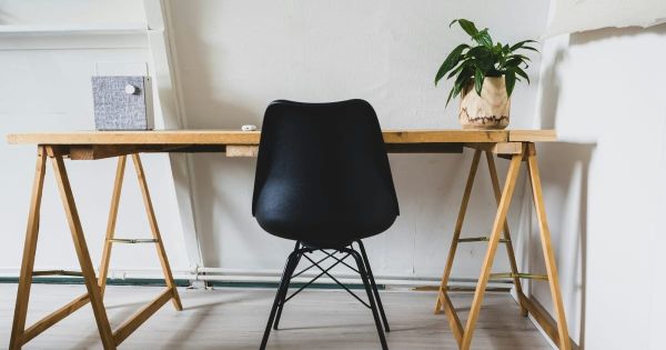 Scrivania minimalista con laptop e quaderno — environment design abitudini