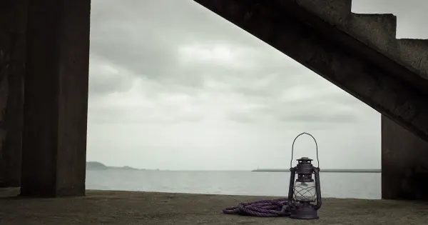 Lanterna spenta su un molo, sotto una scala di cemento, nell'ombra silenziosa di mezzogiorno, lezioni soul sul senso vita