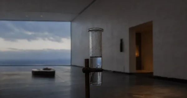 Pluviometro mezzo pieno che riflette il cielo, in una sala museale vuota, all'ora blu, mantra crescita personale