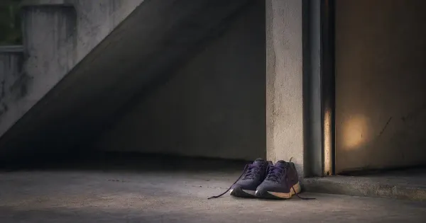 Scarpe da corsa in parallelo sulla soglia, sotto una scala di cemento, nel silenzio profondo d'estate — lezioni michael…