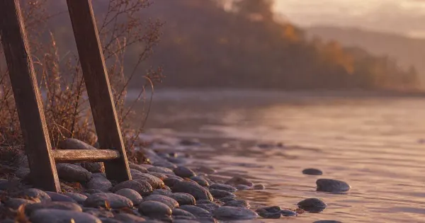Bollitore su fornello freddo, coperchio storto, su una riva di pietre lisce, in sole pallido d'inverno — tiny habits metodo