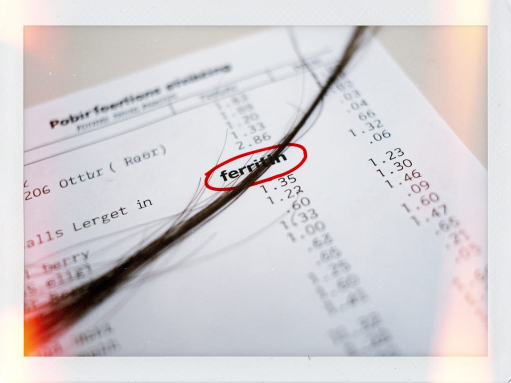 A single hair on a lab report with ferritin circled