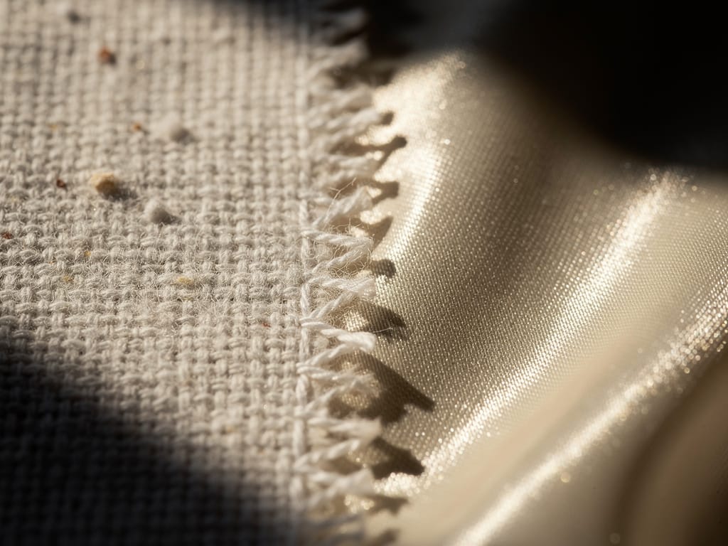 A split-view close-up of rough cotton versus smooth silk fabric