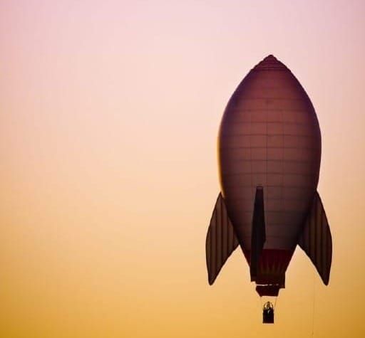 A rocket shaped balloon launching at sunrise - photo by Zeb Palmer