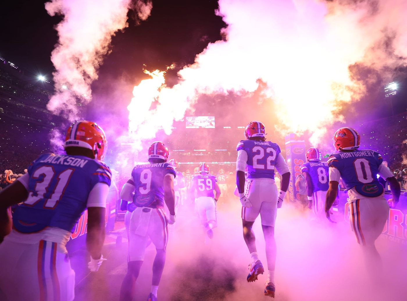 Florida football players run onto the field through smoke at Ben Hill Griffin Stadium