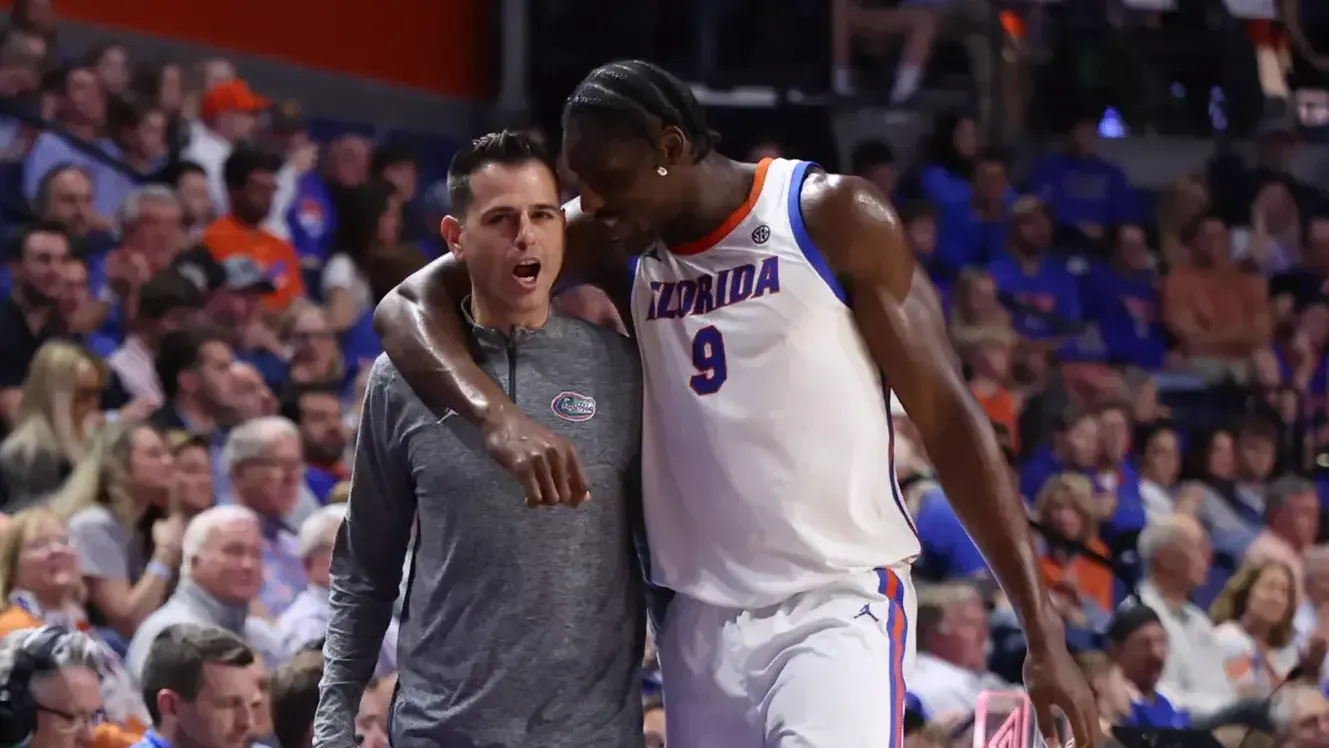 Florida coach Todd Golden puts his arm around center Rueben Chinyelu during a game at the O'Connell Center