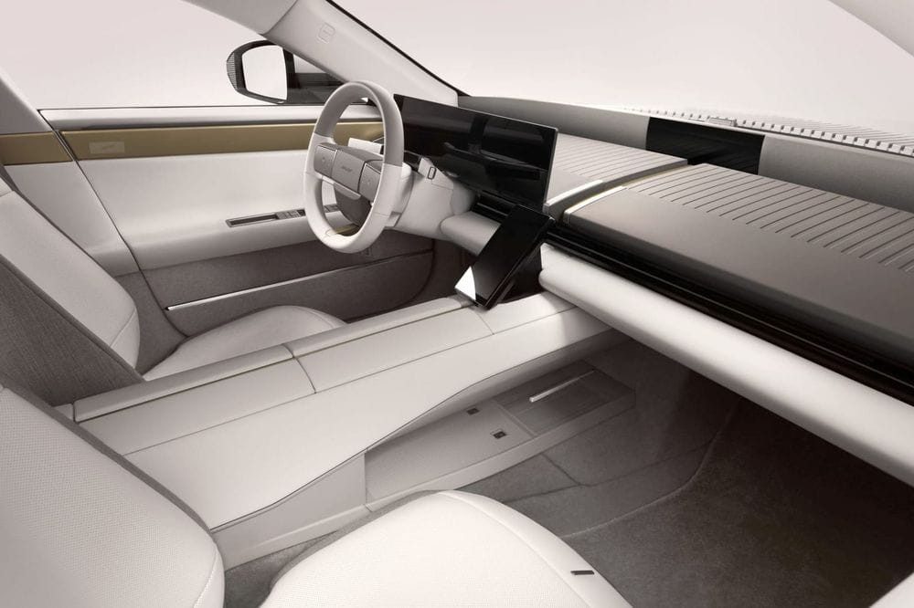 Pale minimalist Jaguar Type 01 interior with a wide dashboard display and squared-off steering wheel