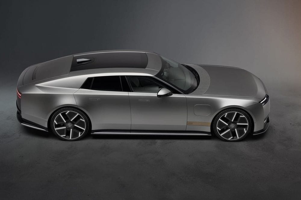 High side view of a silver Jaguar Type 01 electric grand tourer with a long bonnet and low roofline