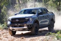 Grey Ford Ranger Tremor ute with a sports bar driving over rocky dirt, kicking up dust