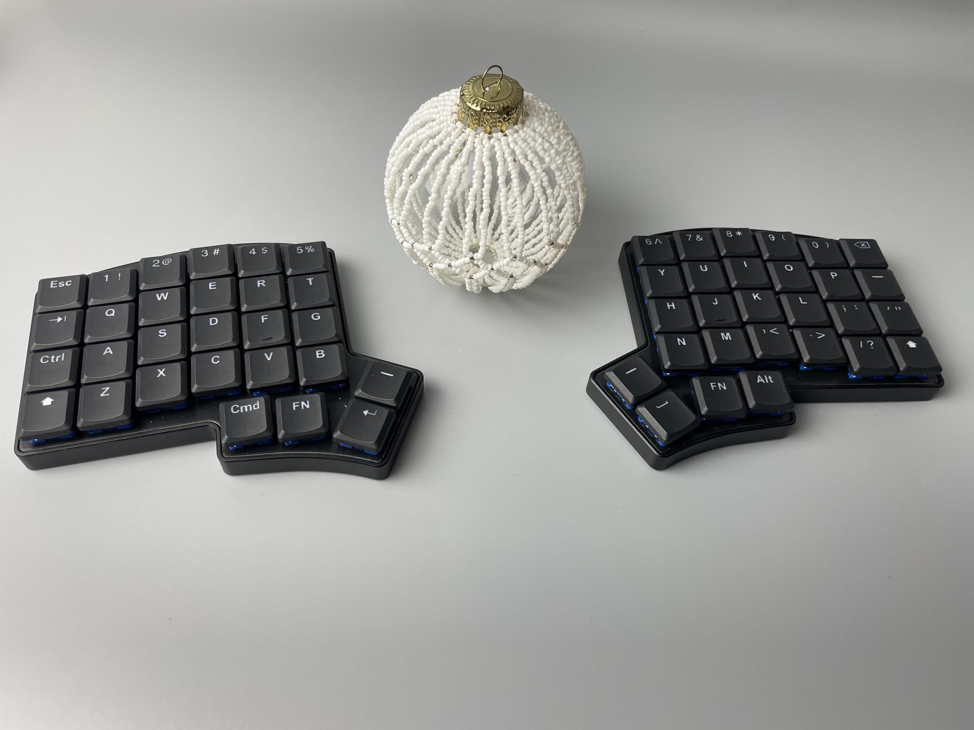 Keebio Iris LM with a beaded ball ornament between the halves