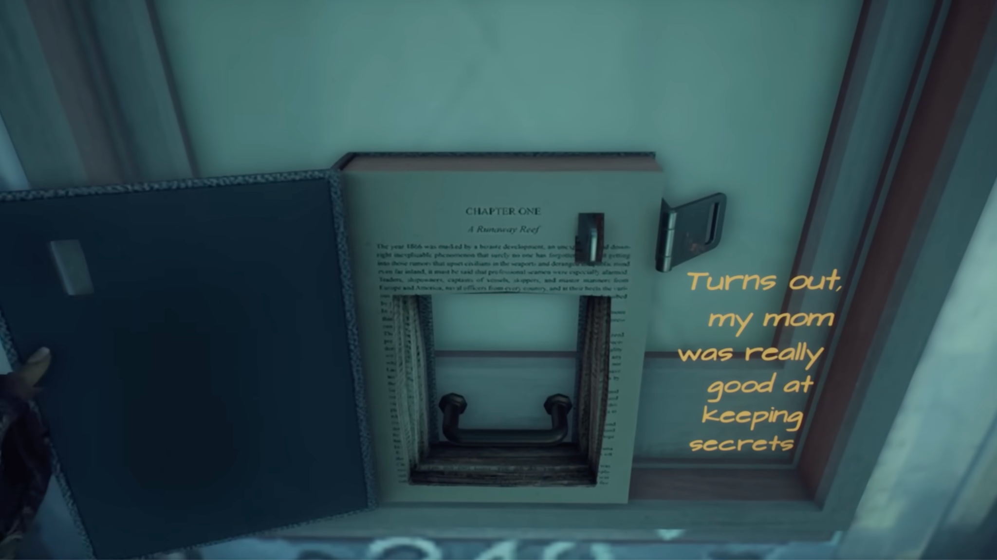 A screen capture from What Remains of Edith Finch: Edith uses the key her mother left in her will with no explanation to open "Twenty Thousand Leagues Under the Sea." Beneath the cover is a handle. Edith intones, "Turns out, my mom was really good at keeping secrets."
