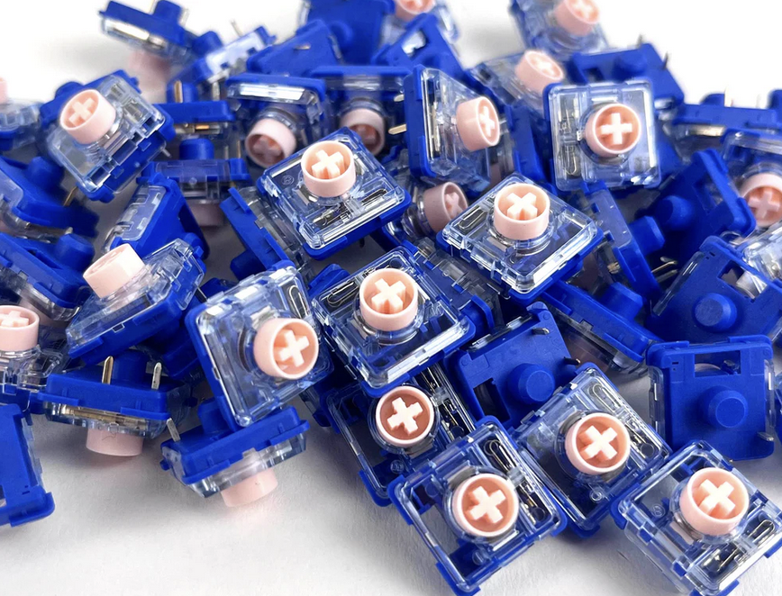 A picture of a pile of the Deep Sea Mini Pink Island switches, which are extra-light linears at 35g.