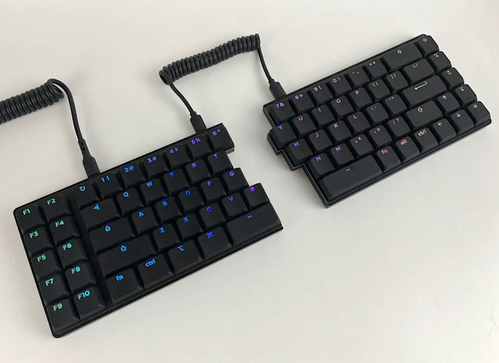 The Quefrency LM is pictured with its macro section, Deep Sea Mini Whale Silent Tactiles, LPF Shine keycaps and coiled cables connecting the halves.