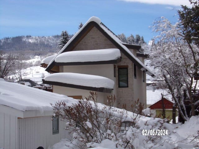 The new building rises behind the low roof of the 1910 house on Feb. 5, 2024, seven months before the deadline to demolish the old house passed. (Routt County Assessor’s Office)