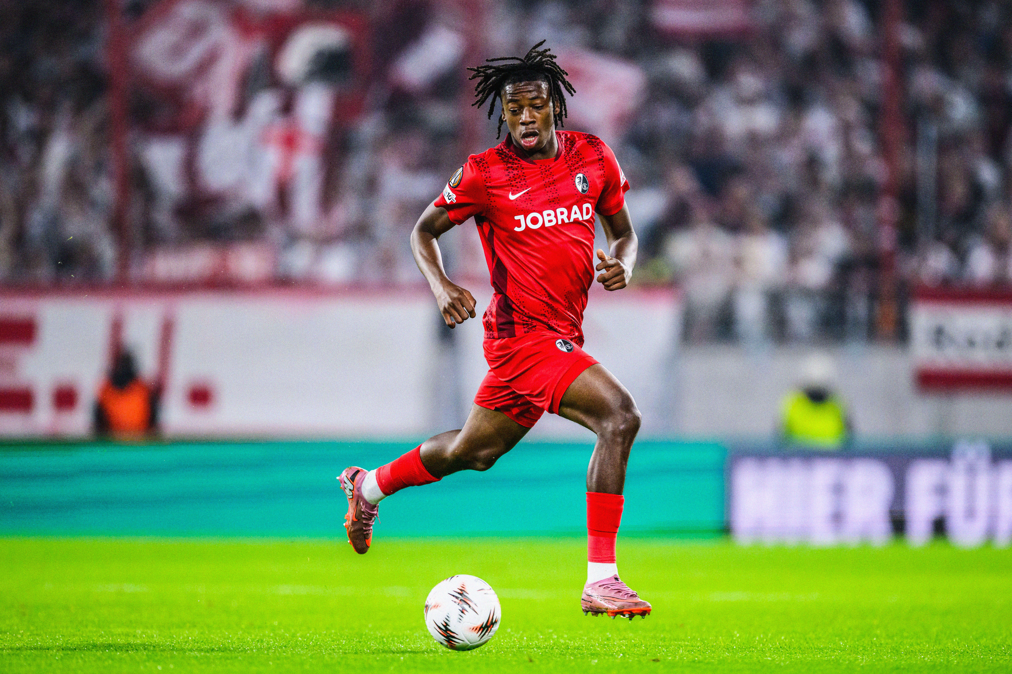 Johan Manzambi running with the ball in a UEFA Europa League match for SC Freiburg