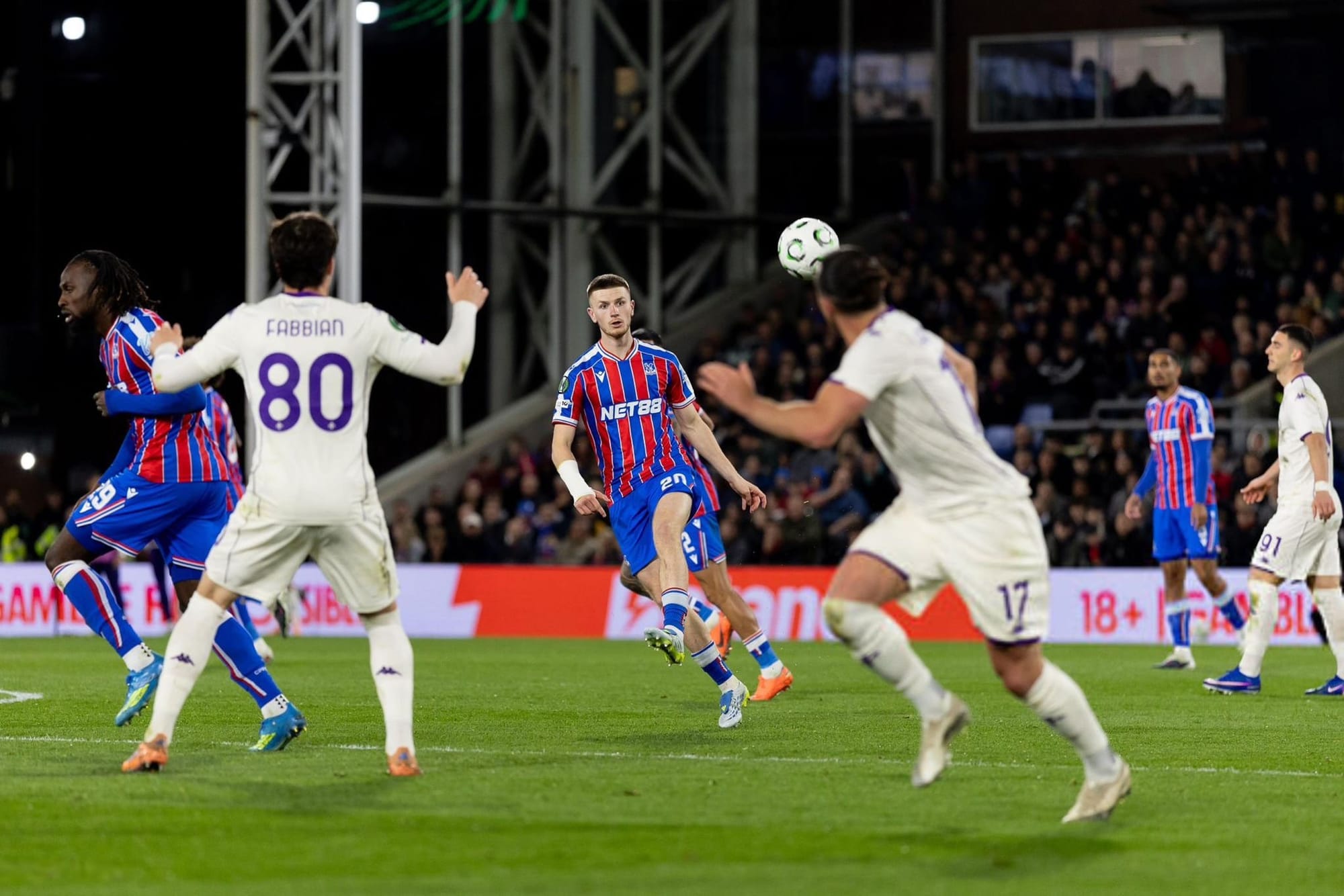 Photo of Crystal Palace's Adam Wharton clipping a left-footed pass over Bologna defenders in a UEFA Conference League match