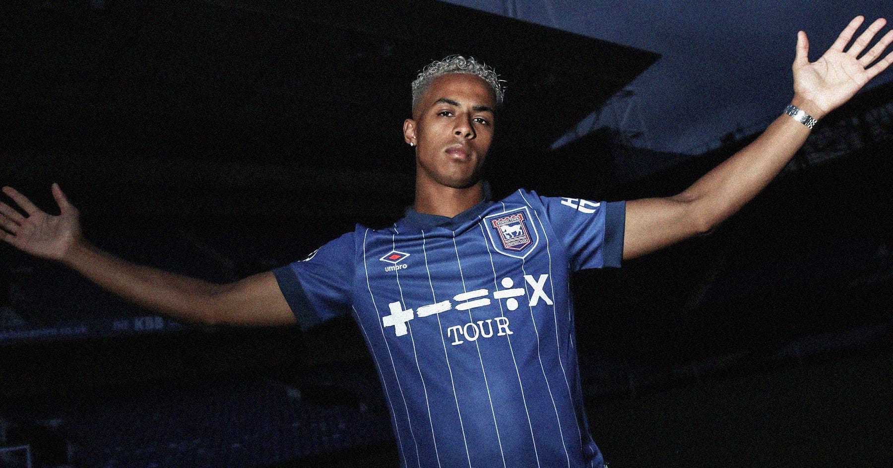 A photo of Omari Hutchinson wearing a blue Ipswich Town shirt at a dark Portman Road