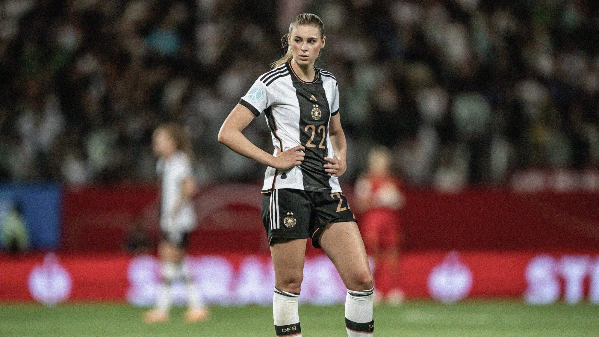 A photo of Jule Brand standing with her hands on her hips while playing for Germany