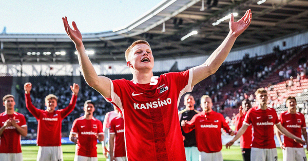 Kees Smit cheering with fans, stood with his arms spread wide, wearing a red and white AZ Alkmaar shirt