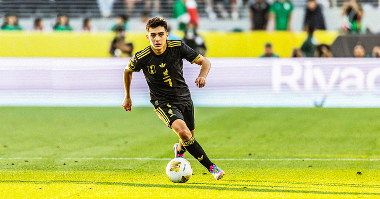 Gilberto Mora running with the ball for Mexico, wearing an all-black kit with yellow accent colou
