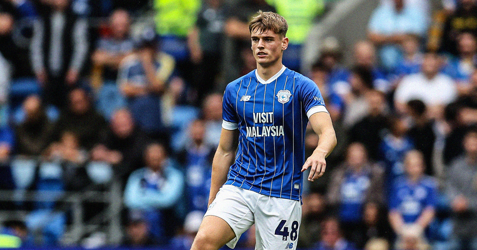 Dylan Lawlor playing for Cardiff City, wearing a blue shirt with white stripes and shorts