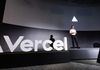 Vercel CEO Guillermo Rauch speaks on a stage next to Vercel's logo wearing a white t-shirt and black pants