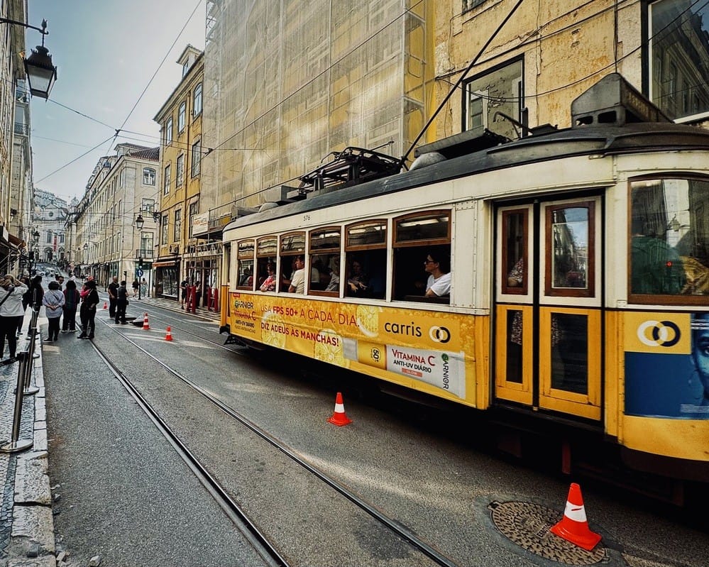 The entrance of the Roman Galleries in Lisbon, with Tram 28 passing by