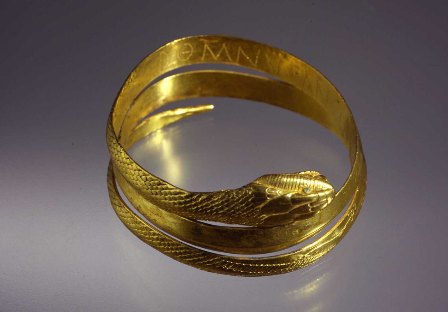 A rare Roman slave armille collar made of gold and glass, depicting a snake  with engraved inscription DOM(I)NUS ANCILLAE SUAE