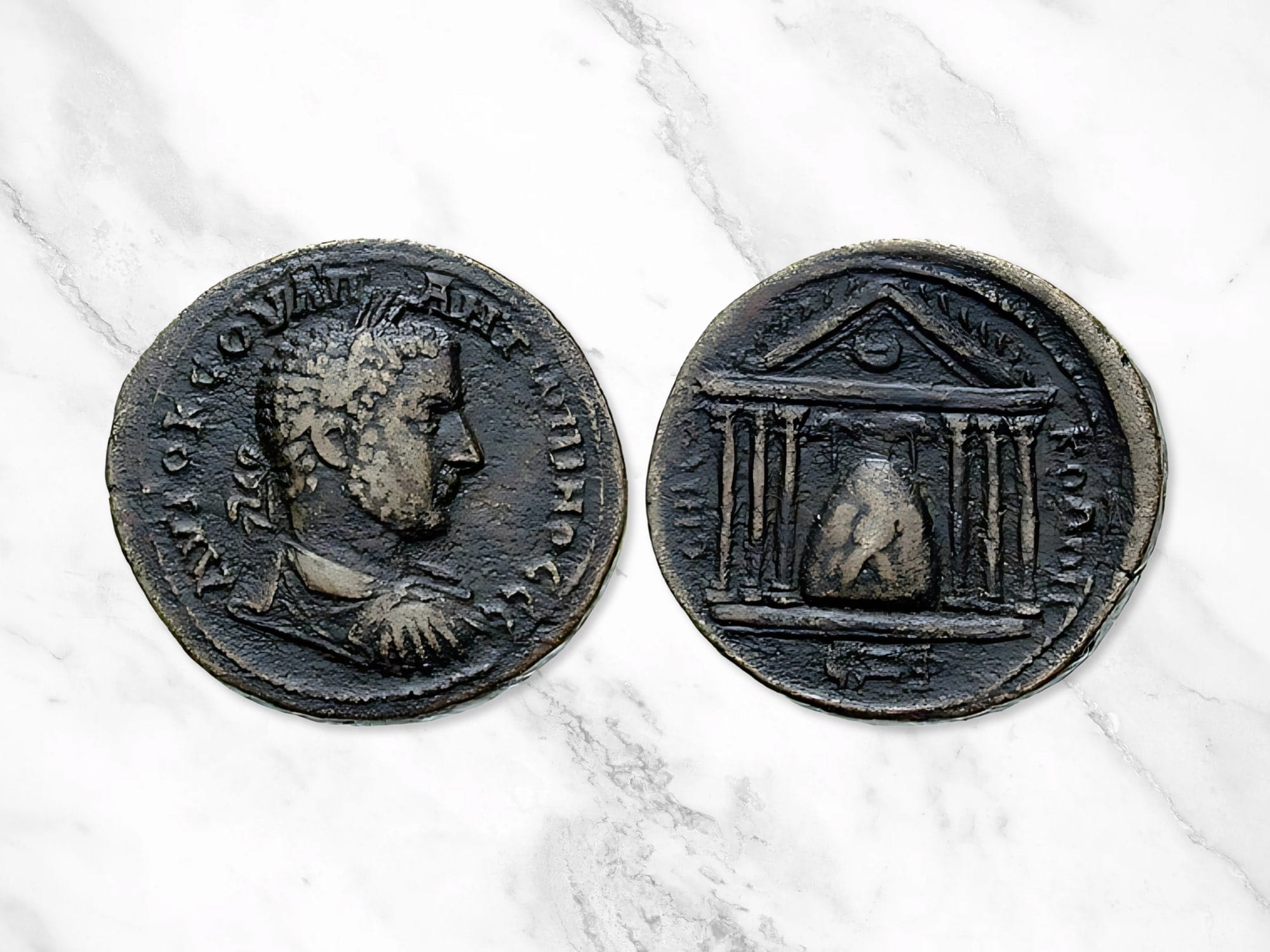 A Roman coin depicting EMICΩN KOΛΩN in the back, the hexastyle temple containing the conical stone of Elagabal