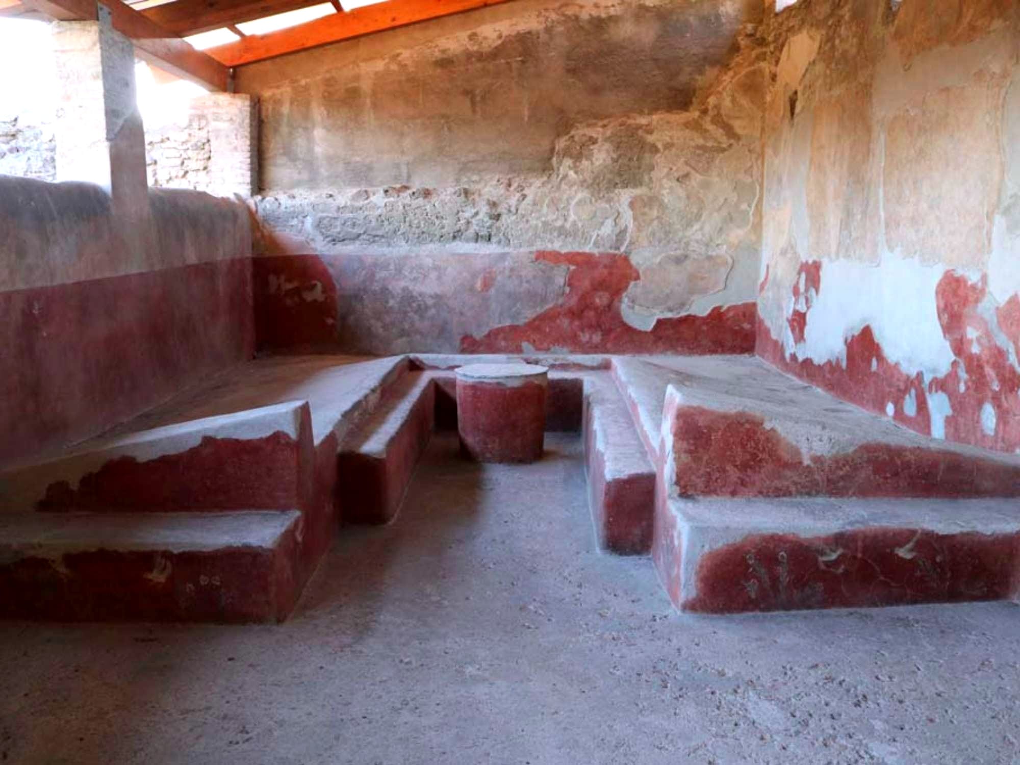 Triclinium with table, against the west wall of the loggia. The circular table, the couches and the benches, were all painted with motifs of plants and birds on a red background.