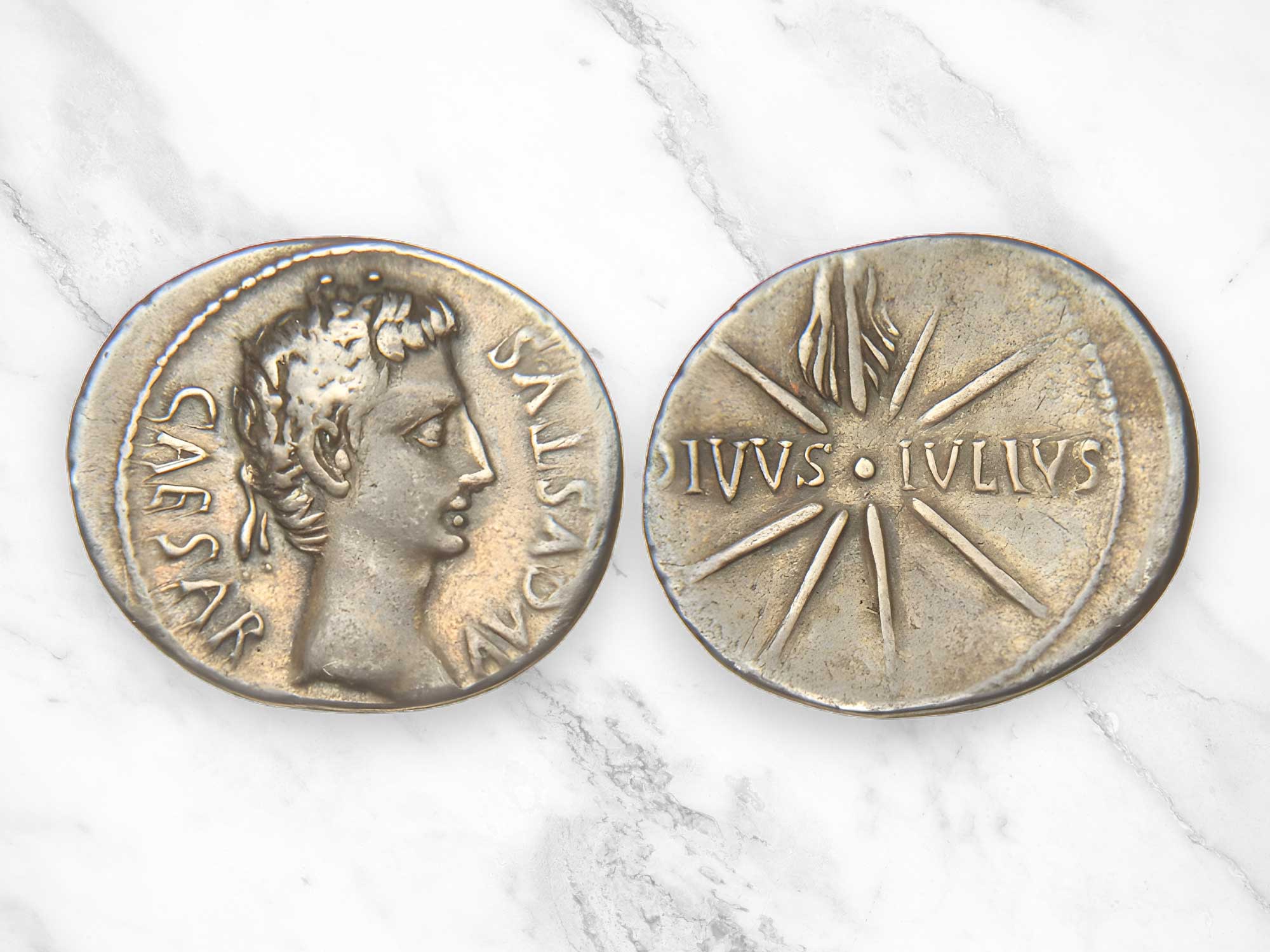 An ancient Roman coin with the DIVVS - IVLIVS inscription and the eight-stream Comet Caesar with upward tail (sidus Iulium