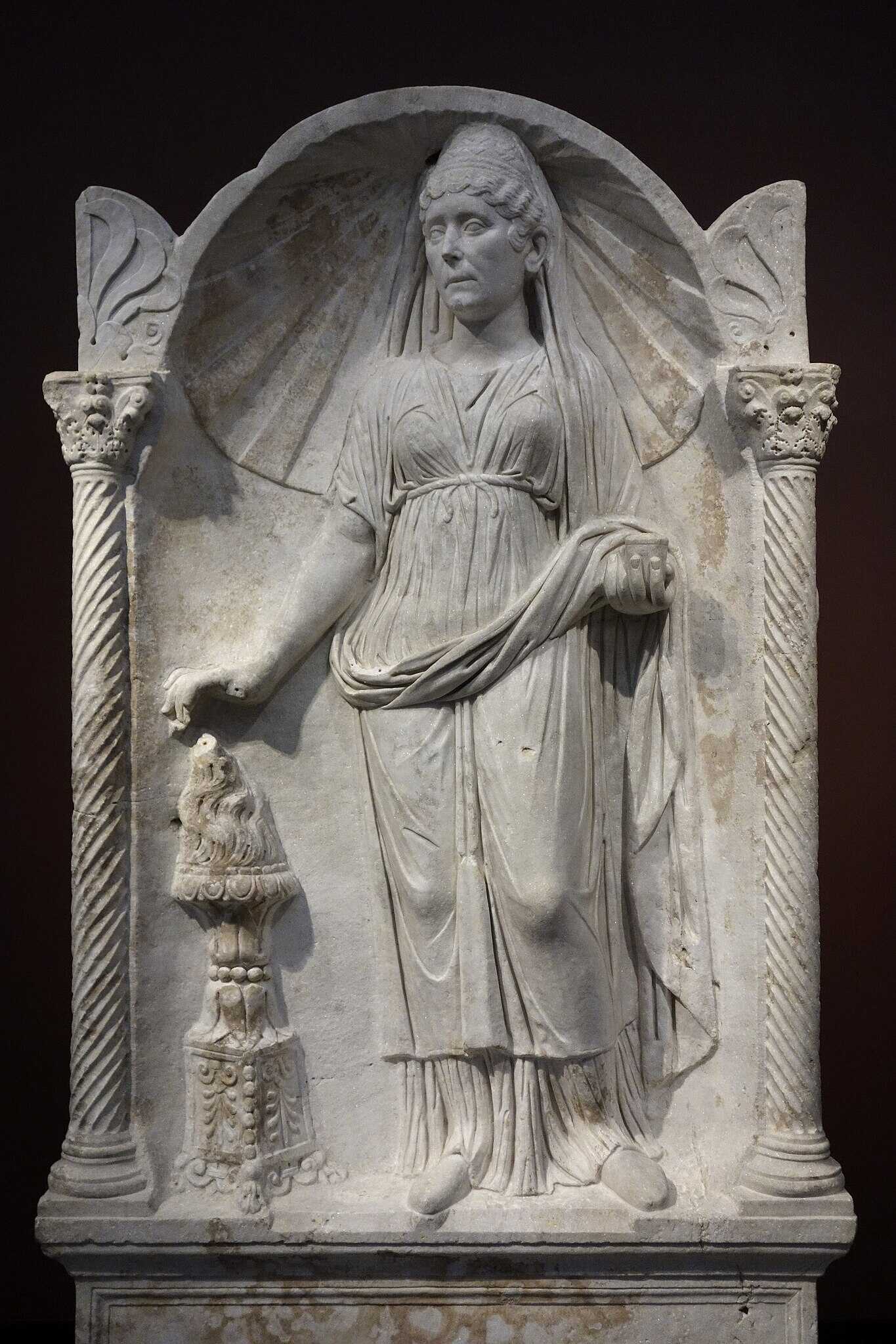 Funerary altar of a Roman woman. In her left hand she holds a jar of incense; with her right hand she sprinkles it over a flaming thymiaterion